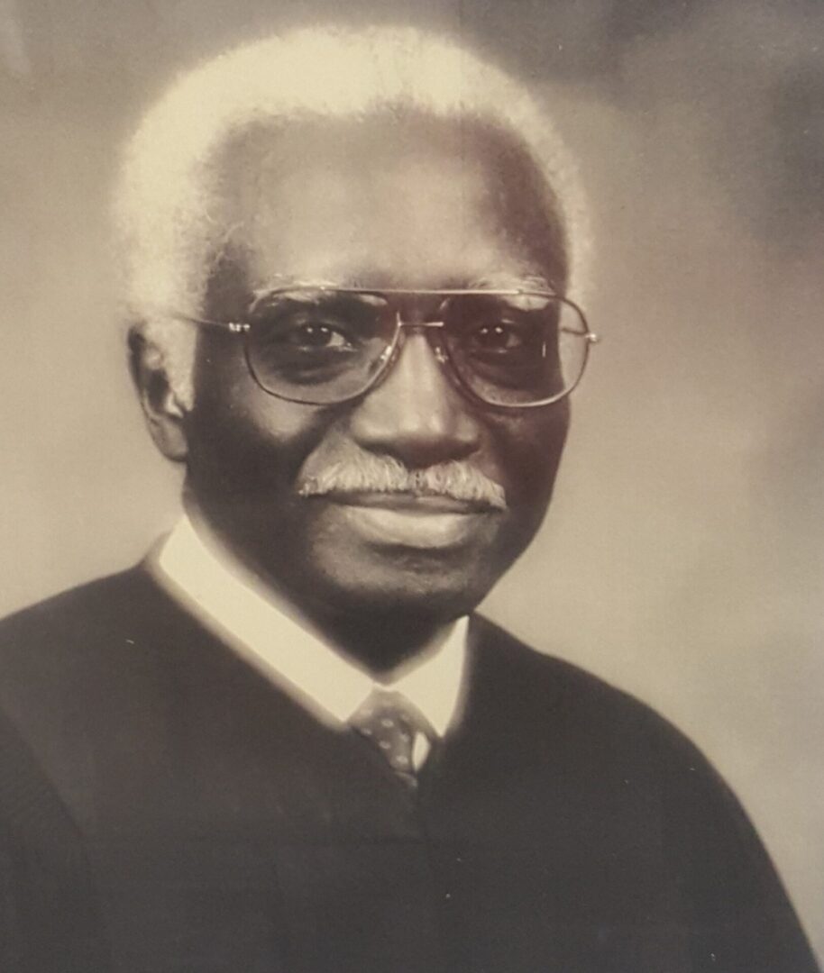 Portrait of an elderly man with white hair and glasses.