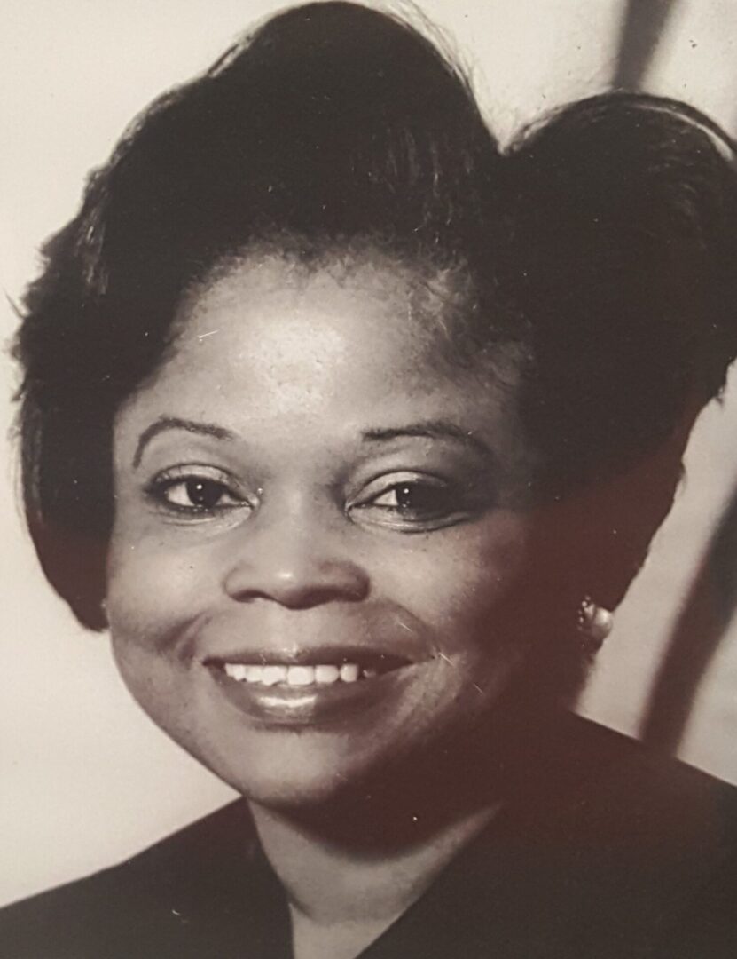 Black and white portrait of a smiling woman.