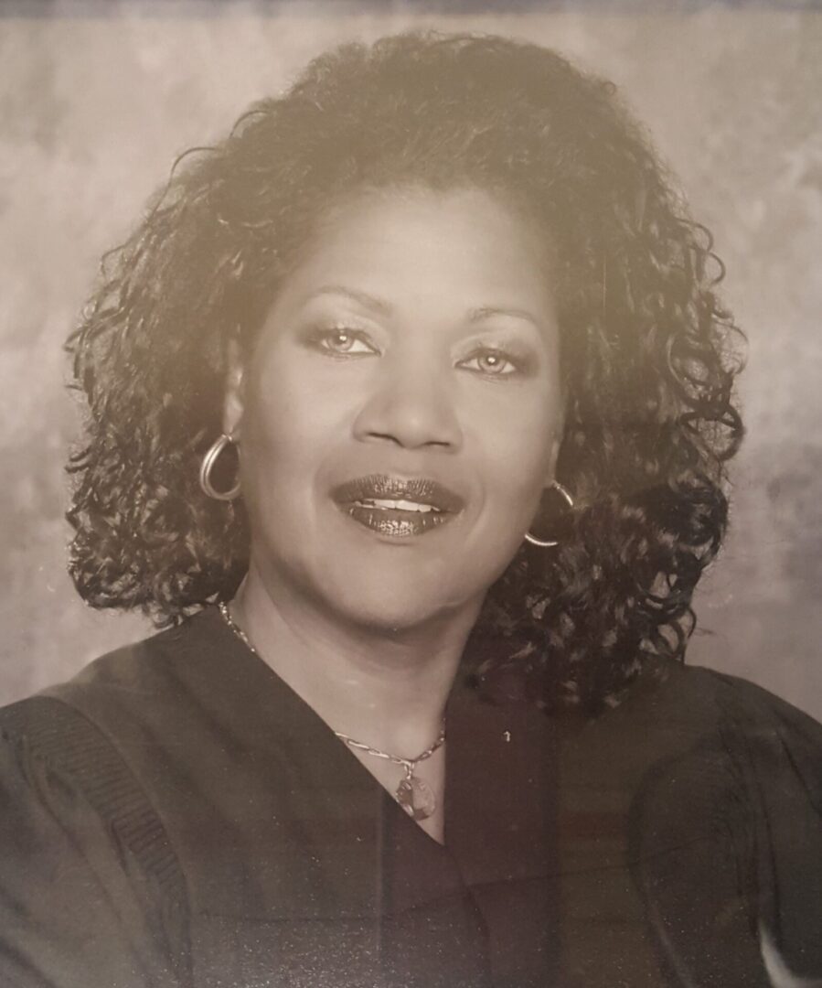 Portrait of a smiling woman with curly hair in black and white.