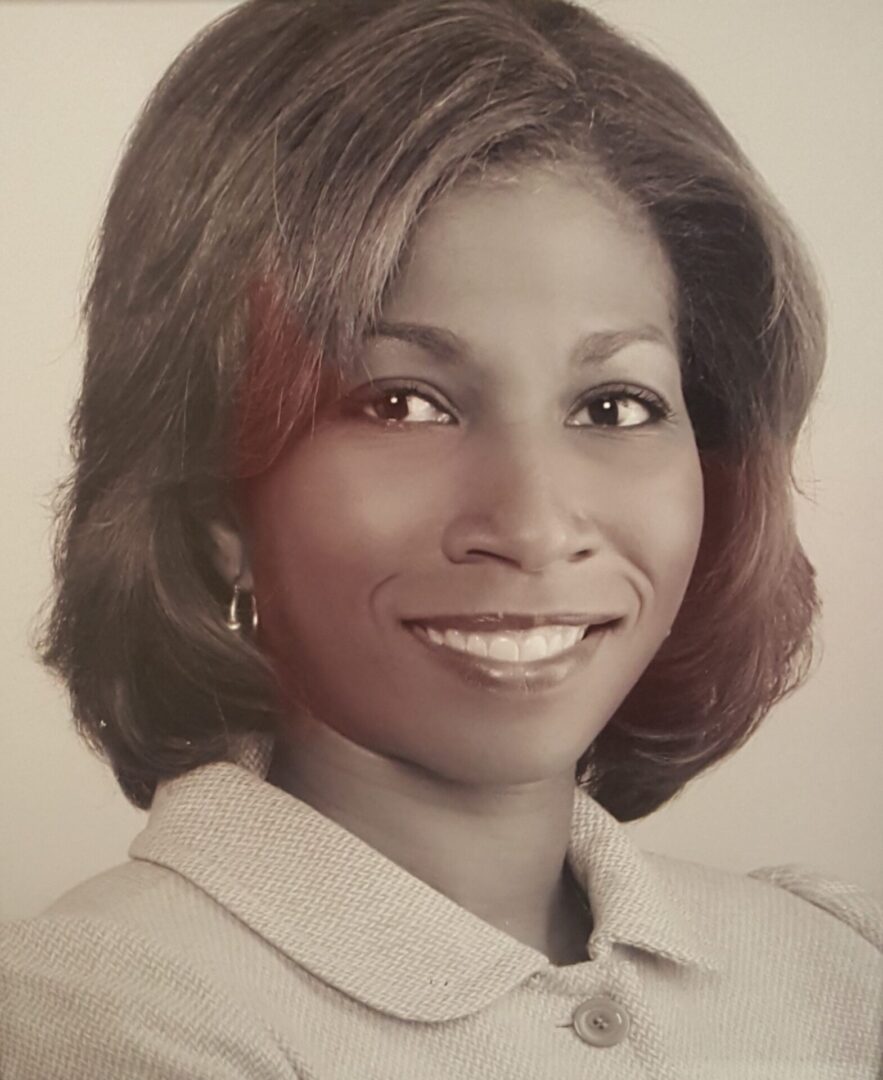 A woman smiling warmly in a professional portrait.