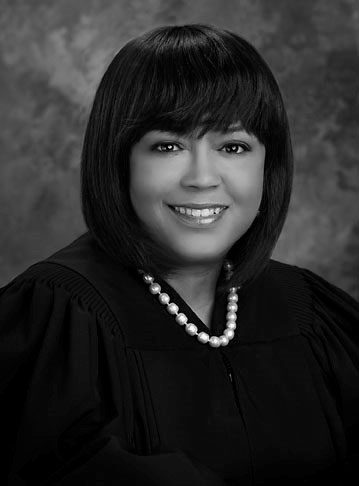 Black and white portrait of a professional woman in judicial robes and a pearl necklace.
