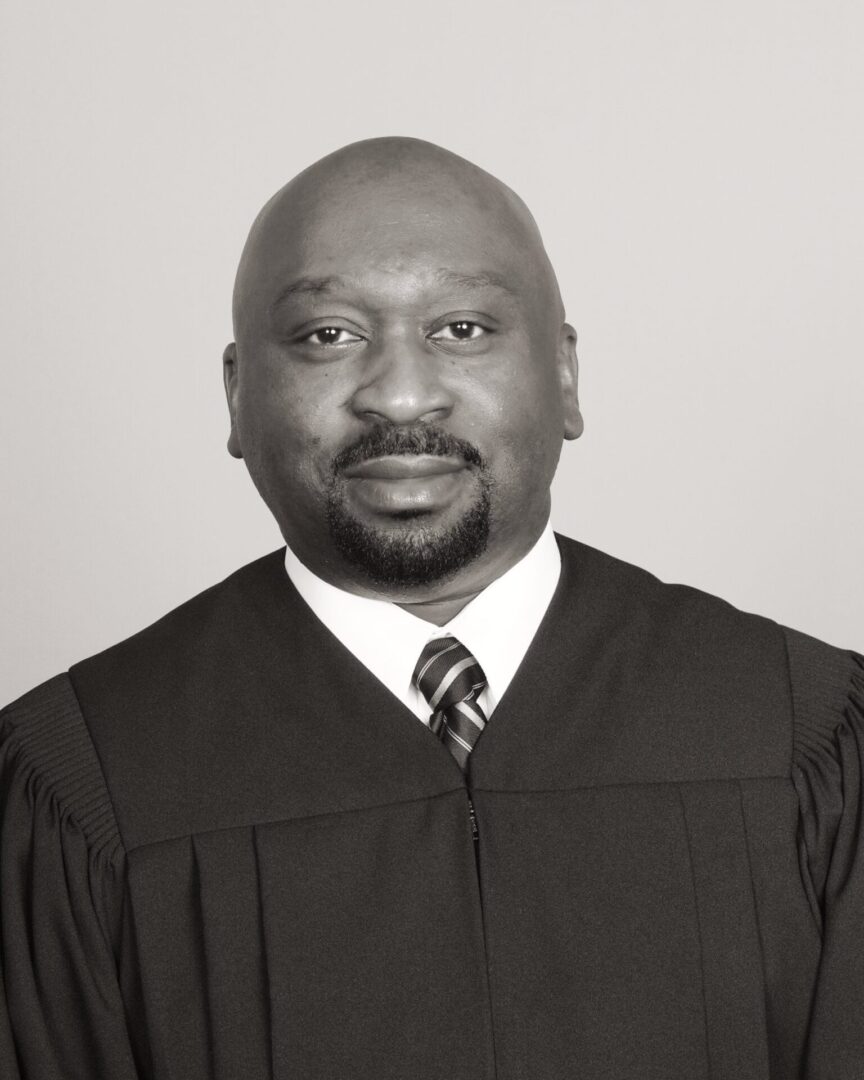 Portrait of a man in judicial robes and tie.