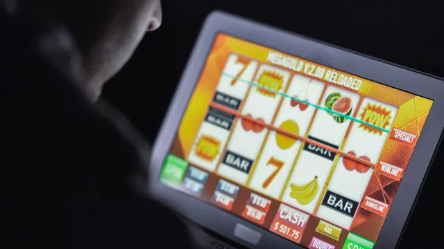 Person playing a digital slot machine on a touchscreen device.