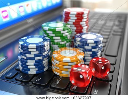 Colorful poker chips and red dice on a laptop keyboard.