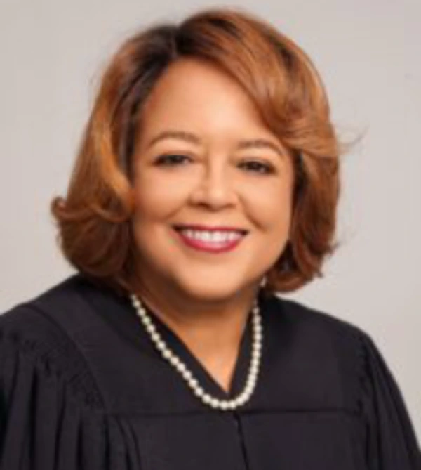 Portrait of a smiling woman in a judicial robe and pearl necklace.