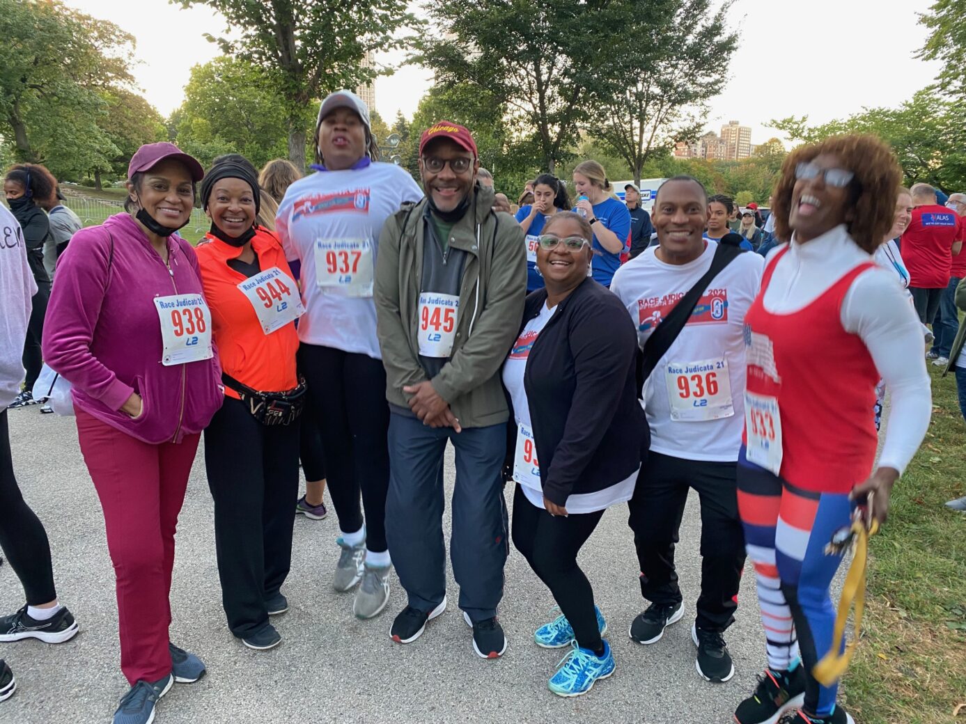 A diverse group of runners posing together outdoors before a race.