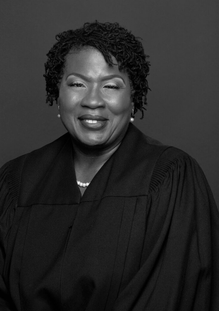 Black and white portrait of a smiling woman in judicial robes.