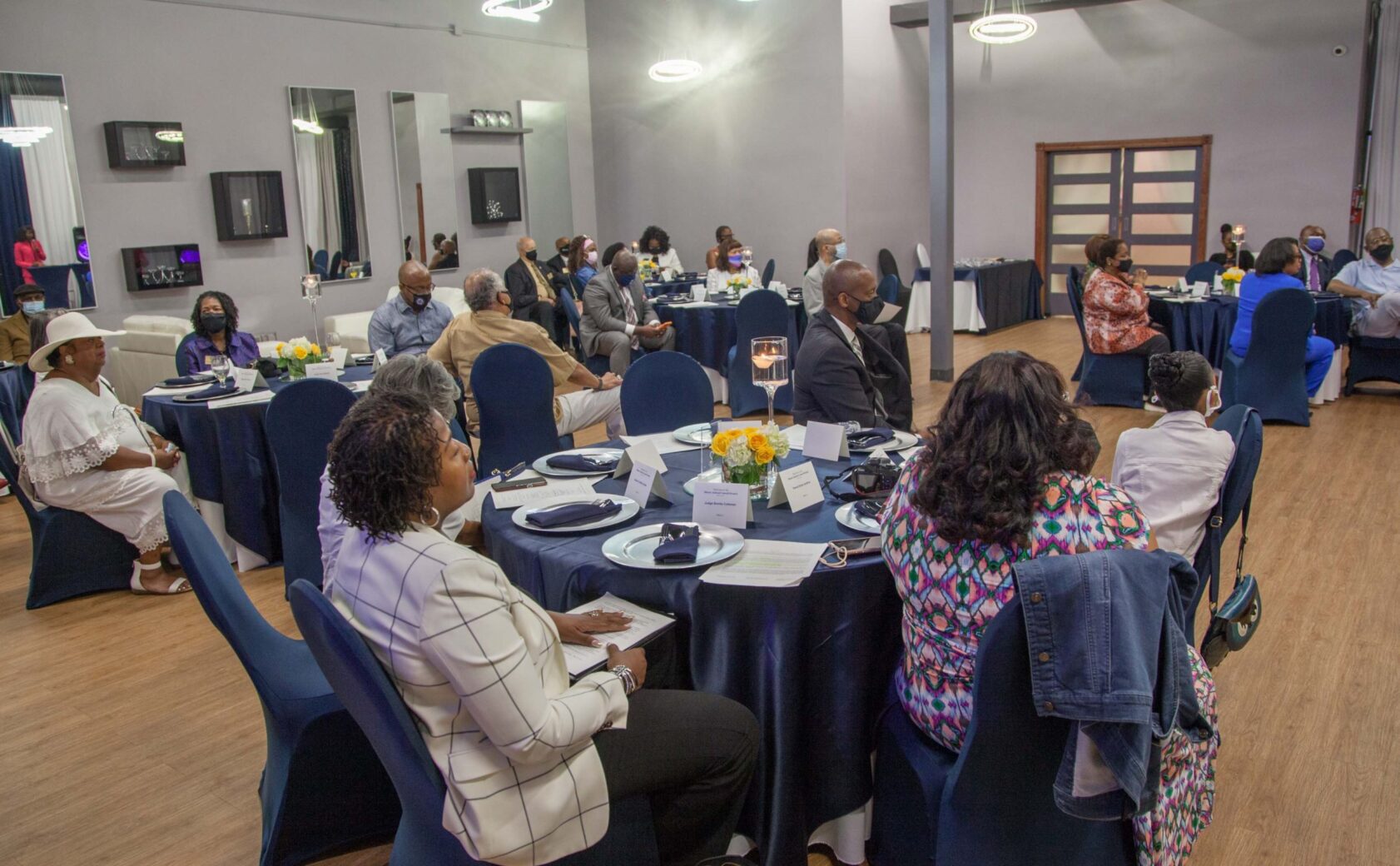 People gathered at round tables for a formal event or meeting.