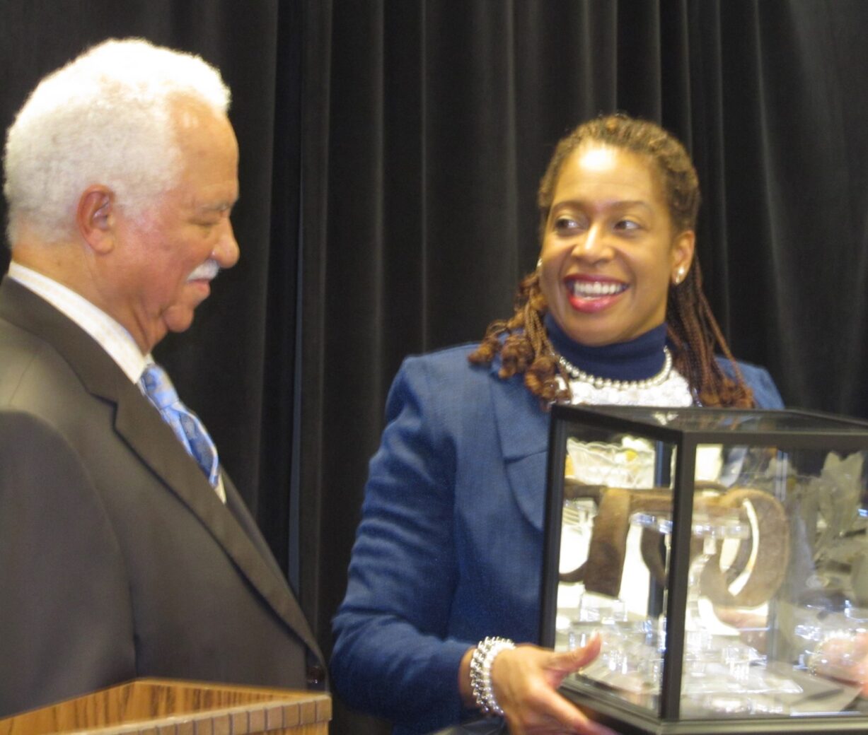 Smiling woman holding a trophy case