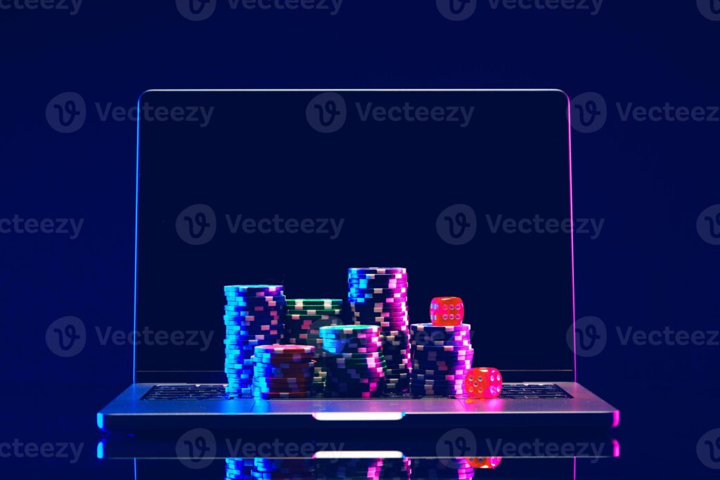 Colorful poker chips stacked on a reflective surface with a dark background.