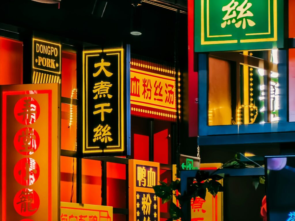 Vibrant neon signs illuminate a bustling urban street at night.