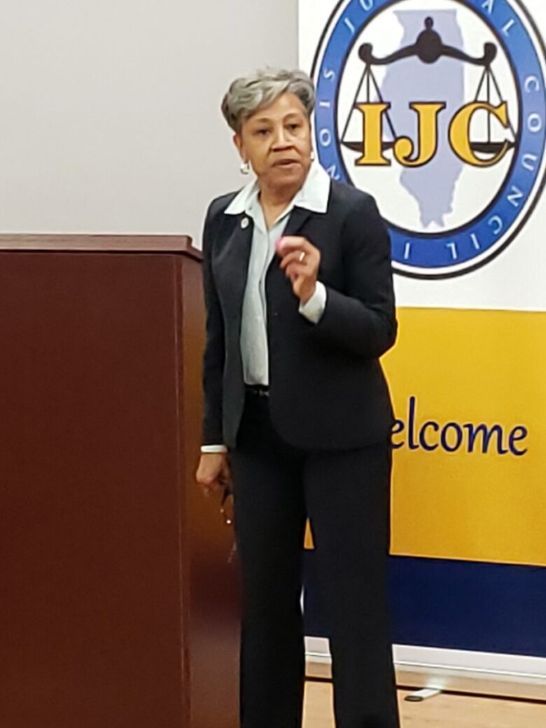 A woman in a suit giving a presentation indoors.