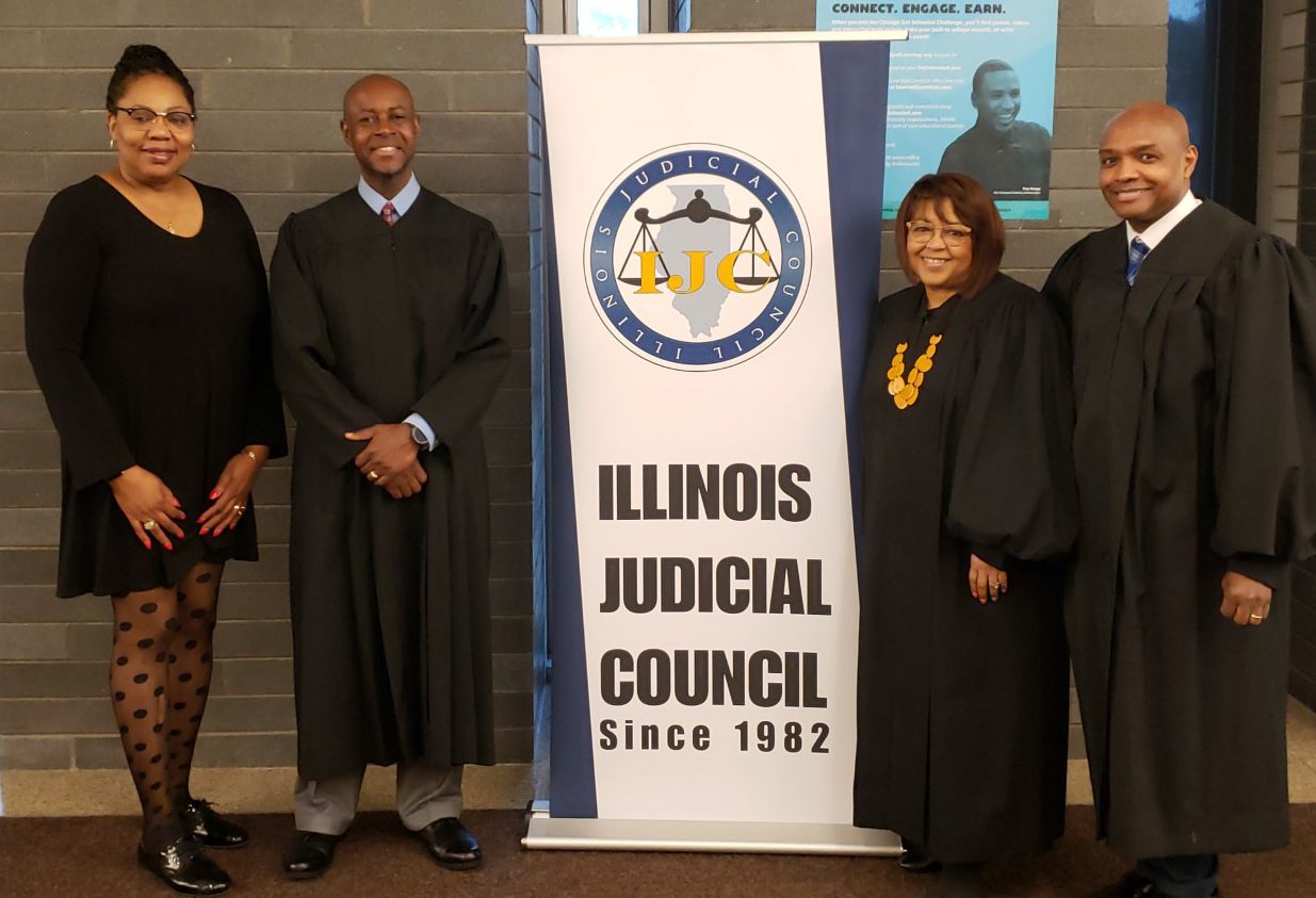 Group of judges beside Illinois Judicial Council banner