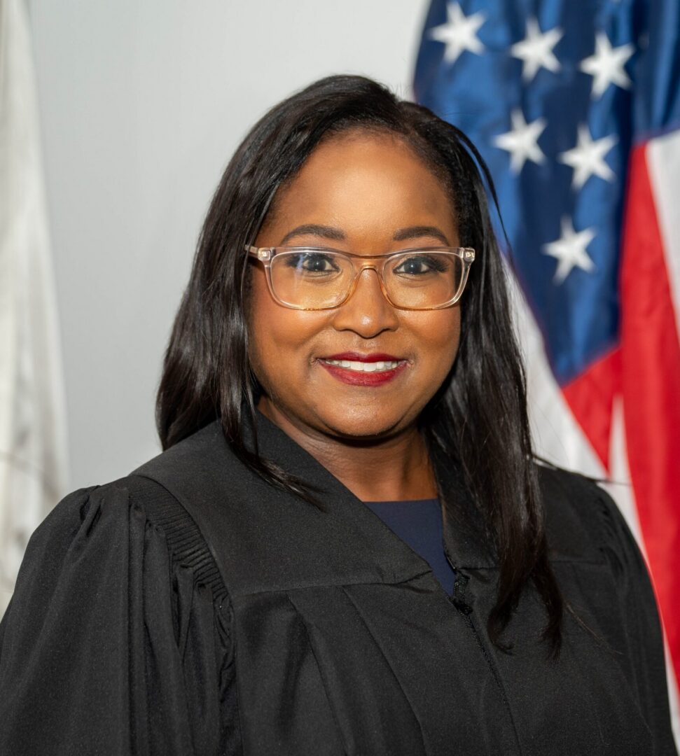 A smiling judge poses in front of the American flag.