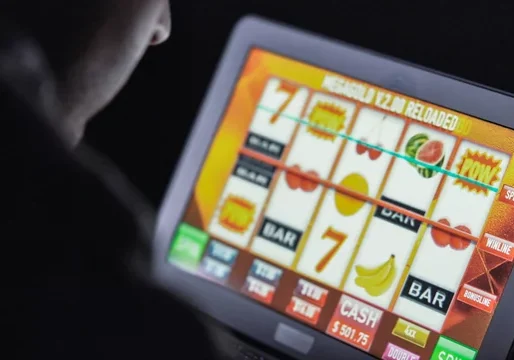 Person playing a digital slot machine on a touchscreen device.