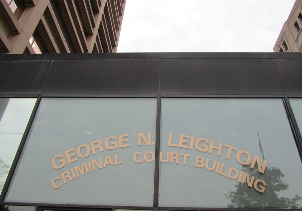 Sign on a building reading 'George N. Leighton Criminal Justice Building'.