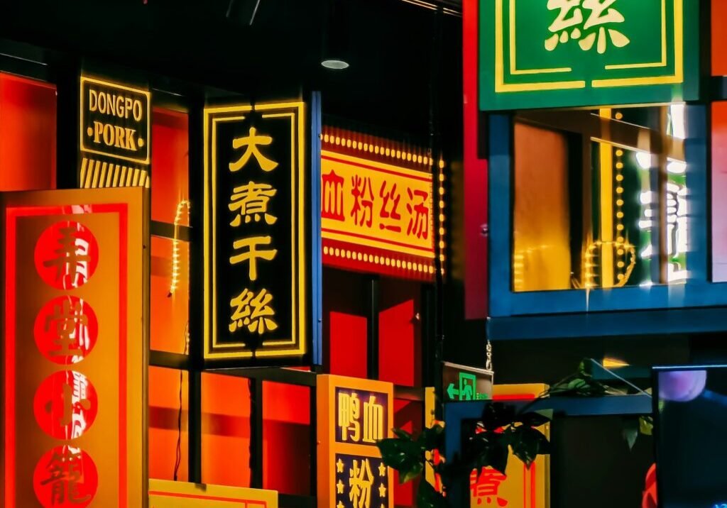 Vibrant neon signs illuminate a bustling urban street at night.